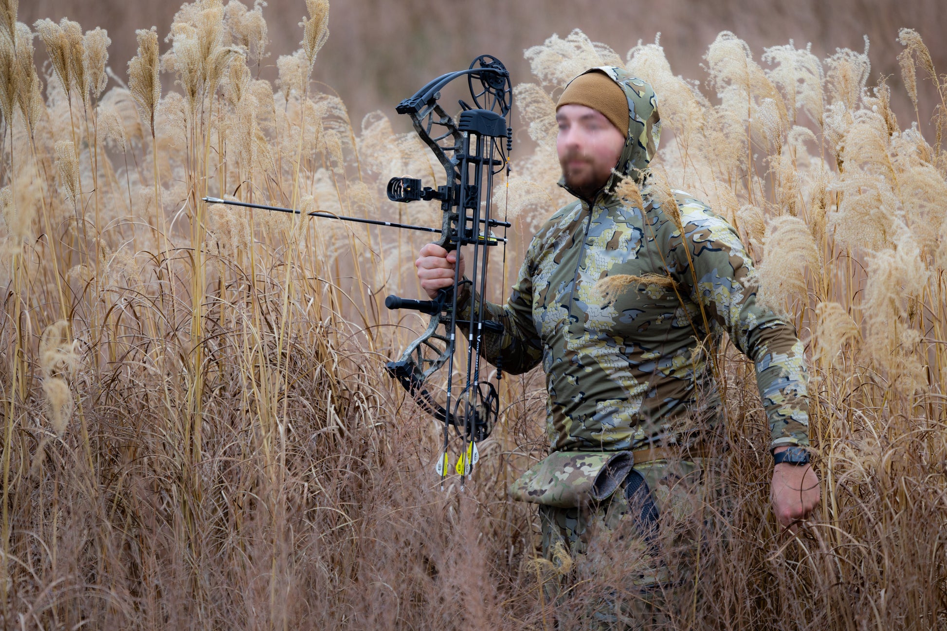 Bowhunter in MultiCam camo using Combat Effective wool hand warmer muff in treestand setup